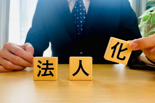 法人化の積み木を並べるビジネスマン